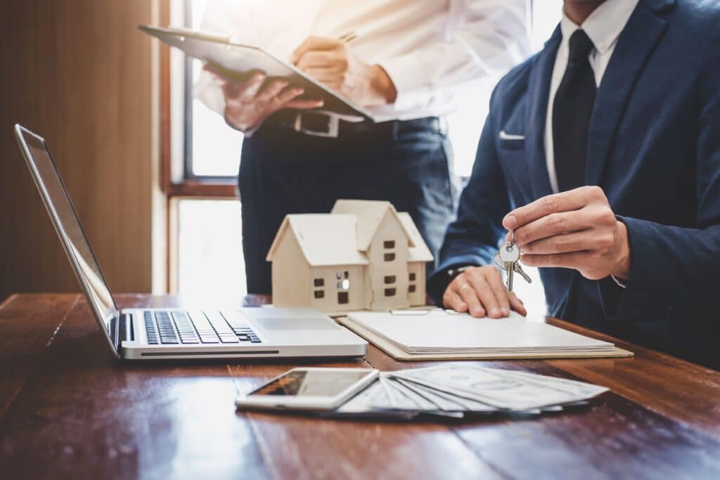 A real estate agent and a client engaged in discussion at a desk