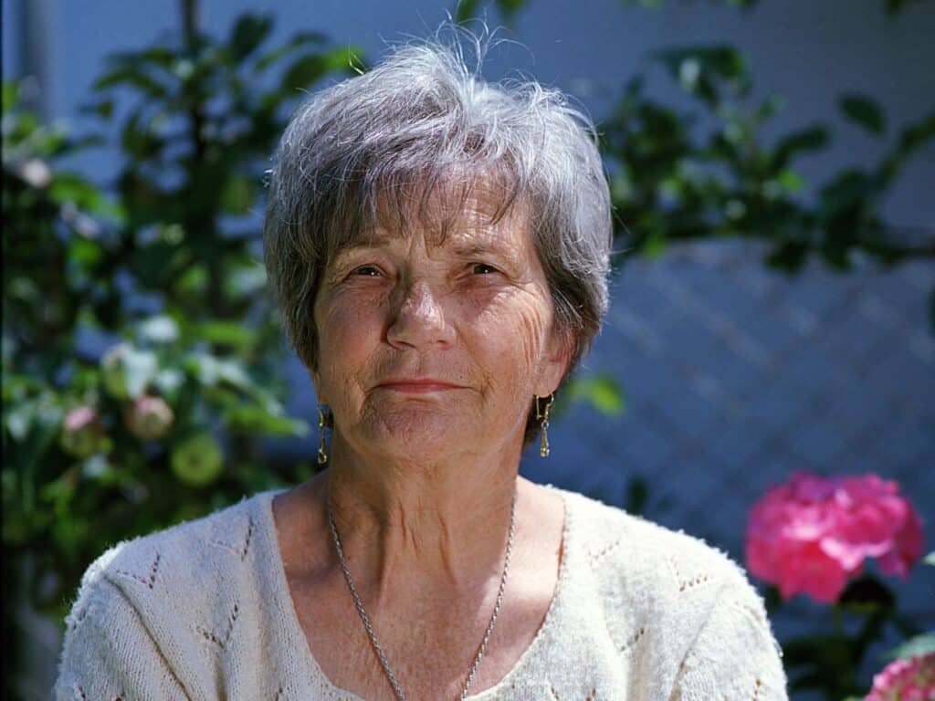 An older woman with gray hair smiles warmly